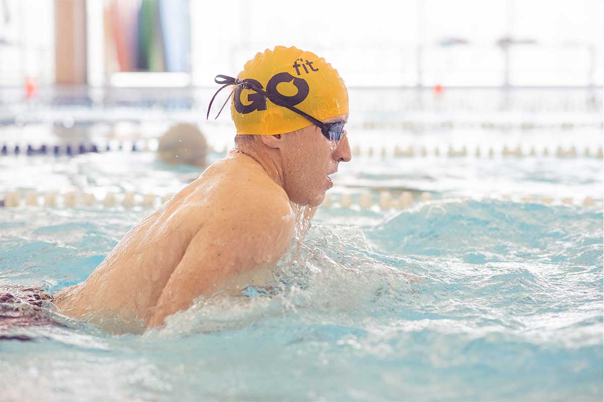 hombre con gorra de natacion nadando en piscina